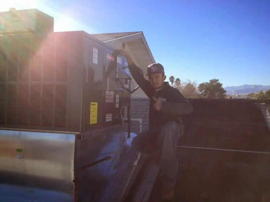 HVAC technician performing HVAC Inspection on a rooftop unit in Rome